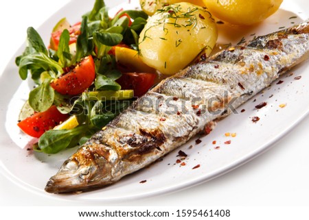 Fish dish - grilled herring with vegetables on white background

