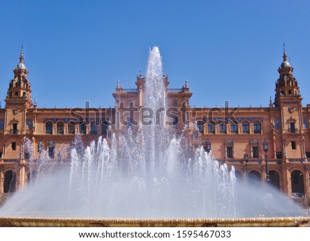 View of the Vicente Traver fountain facing the central building of Plaza de España in Seville, Spain, on a sunny day