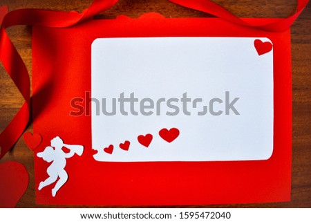 Valentine’s Day, love concept. Cupid with a trumpet and red hearts. Copy space, white background. Place for words