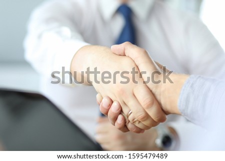 Closeup of business handshake after signing new contract at the office.
