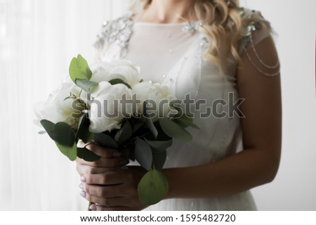 wedding bouquet of white peonies in the hand of the bride on the wedding day. 