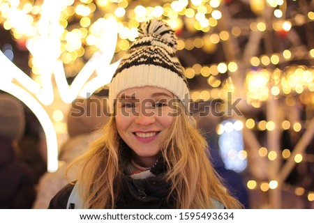 Happy woman outdoor portrait on christmas light bokeh background.