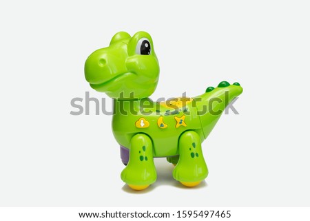 Dragon plushie doll isolated on white background with shadow reflection. Dragon plush stuffed puppet on white backdrop. Dino plushie toy. Green color stuffed dinosaur toy. Lizard toy sitting on white