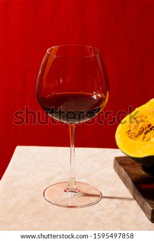 Chianti, italian red wine from Tuscany, near a sliced pumpkin. Colorful background