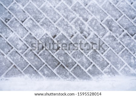 Texture of snowy paving slabs