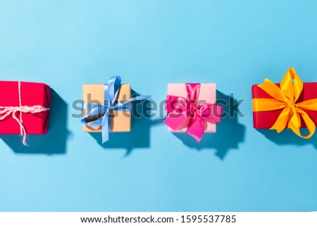 Gifts with a ribbon on a blue background under natural light. Modern. Concept holiday, family, beloved, for him. Flat lay, top view