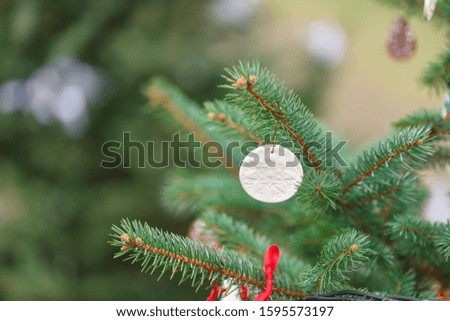 Handmade clay decoration on a Christmas tree outdoor. Diy creative ideas for children. Environment concept. Selective focus, copy space.