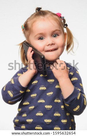 Cute and sincere beautiful girl talking on the phone, portrait of girl 3-4 years.
