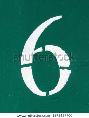 Number 6 white stencil digit painted on rusty metal green surface