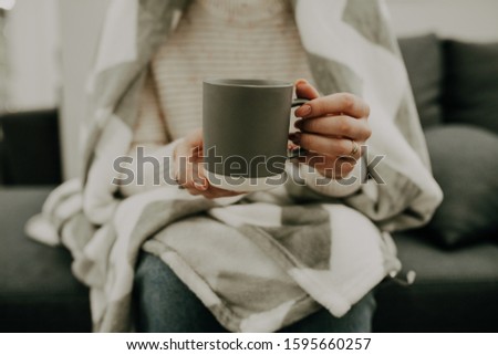 Mug mockup. Women's hands holding gray mug with blank space for your text or promotional content.