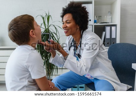 Woman  doctor general practitioner examining child's sore throat
