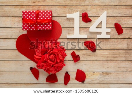 Wooden background with hearts, flowers, gifts, petals and wooden numbers of dated 14 February. The concept of Valentine Day. Top view with space for your greetings.