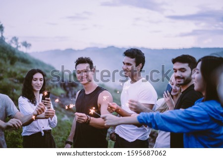 Cheerful diversity friends with sparklers and enjoying together in the evening at outdoor,Happy new year concept