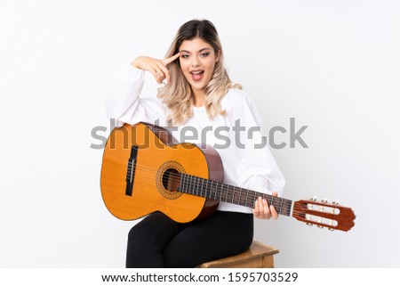 Teenager girl with guitar over isolated white background intending to realizes the solution