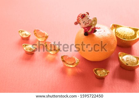  chinese God of fortune and chinese firecrackers and Chinese gold ingots (Foreign text means prosperity, fortune) and Red envelopes and decoration with Fresh oranges on Red Paper background