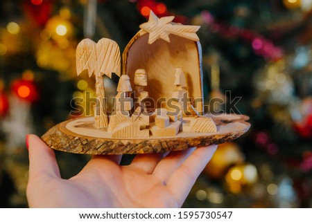 Hand holding wooden christmas crib