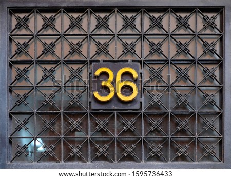 Number 36, thirty-six, golden on black ornamental grill.