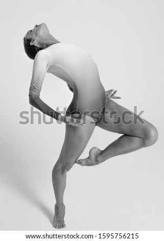 Girl dancer posing on a white background in a photo studio. Professional ballet dancer. Black and white photos. 