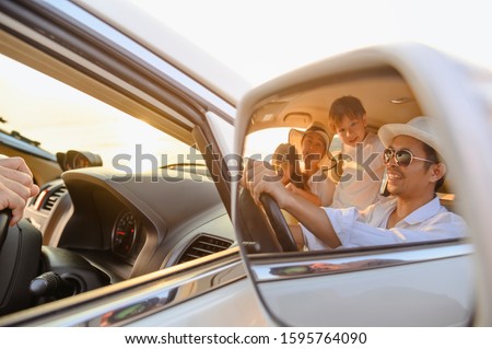 Family, travel, beach, relax, lifestyle, holiday concept. Close-up of images in the side mirror family who enjoy a picnic on the beach at sunset in holiday. 