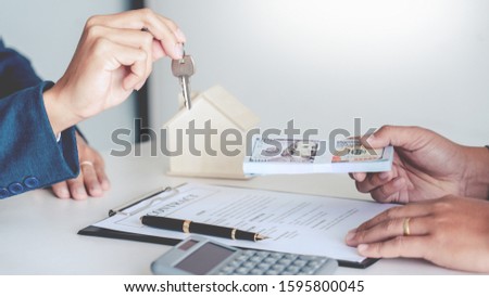 Sale representative offer house purchase contract to buy a house or apartment or discussing about loans and interest rates