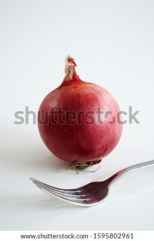 Food photography of a purple onion with fork on white background