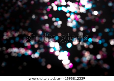 Black background with bright multicolor bokeh lights. Holiday, Christmas and New Year background. Ideal to layer with any design. Horizontal