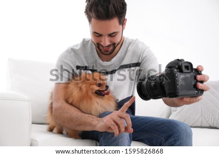 Professional animal photographer taking picture of beautiful Pomeranian spitz dog at home