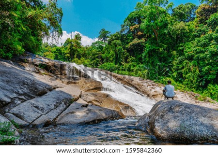 Water fall in forest with green tree and photographer landscape nature background 