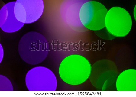 Abstract bokeh light purple and green in the night for background.