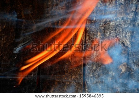 The fire bursting against the wood was a beautiful flame, contrasting with the black background of the smog.