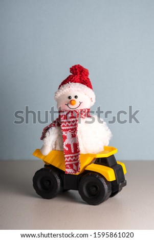 Toy plush snowman in the back of a mining truck. New Year and Christmas plot
