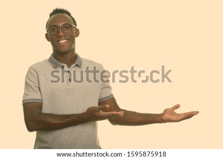 Young happy African man smiling and showing something