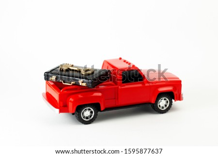 Solutions concept. Red trendy pickup toy with black suitcase and golden key in the trunk. Part of set.