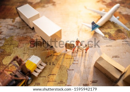 Miniature people: Worker loading box to truck container on world map   using as background business shipping, rent container, worldwide transportation concept.