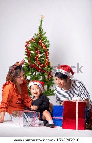 Family very happy with gift a day Christmas and Happy New Year on background in studio.