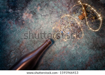 Abstract image of champagne bottle and festive lights.  Flat lay of Christmas, anniversary, carnival, New Year celebration concept. Copy space, top view.