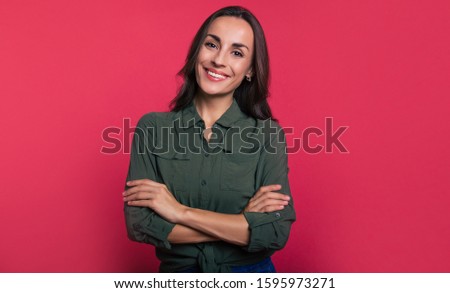A real knockout. A modern business woman in a khaki shirt and blue jeans is posing in front with folded arms, gazing confidently right in the camera.