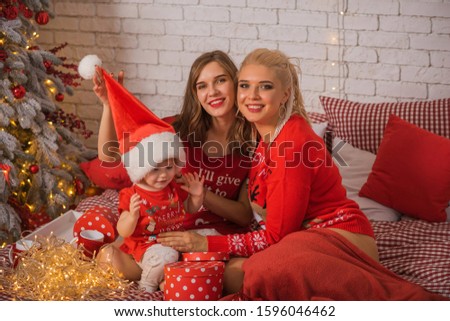 Christmas family scene, two women with a child, happy moms, New year time