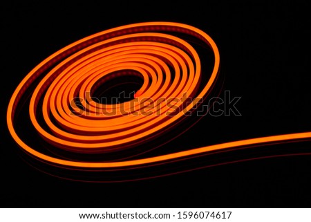 Flexible orange led tape neon flex in roll on black background
