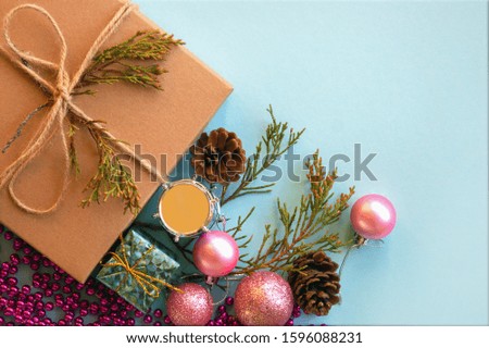 Christmas gift box, decoration and fir tree branch on light blue background. Top view with copy space