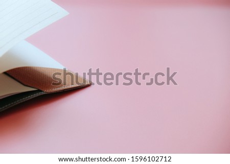Close-up paper note on pink background, brown note with copy space on pastel background