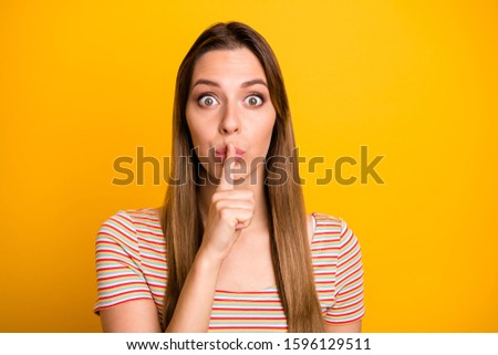 Closeup photo of beautiful lady holding index finger on lips eyes full of fear asking friend keep silence wear casual striped t-shirt isolated yellow color background
