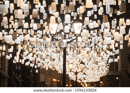 square with lots of glowing garlands and lanterns, decorated for the new year and Christmas to create a festive atmosphere, background texture of bright lights