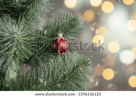 New Year 
decoration on Christmas tree branch, snowy background with bokeh. New Year and Christmas holidays concept.