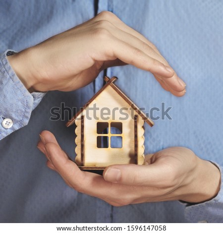 Hand holding small wooden house and protecting. Concept of mortgage, protection. Small house stock image 