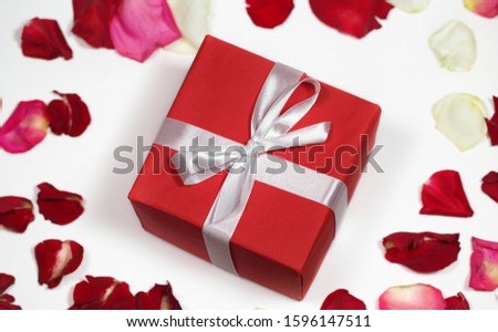 Red gift box on background of rose petals. Valentine day, mother day, wedding, 8 march of concept. Gift stock images