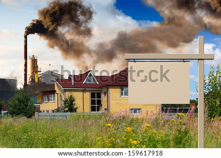 pipe plant polluting sector homes with noticeboard in the foreground
