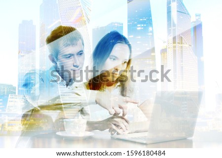 Double exposure. Visual effects. Two colleagues working together on business project using laptop: Caucasian woman shows at screen, pointing at diagrams and graphics on futuristic screen interface