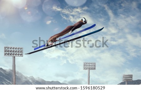 Skier in flight on ski jumping competition. Winter sport.