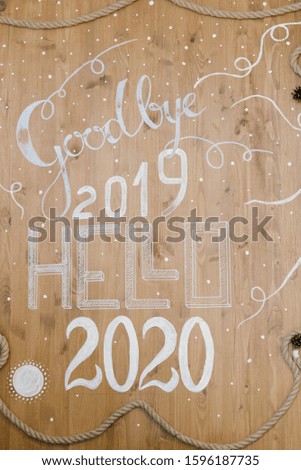Christmas decor, inscription goodbye 2019 Hello 2020 on a wooden background
